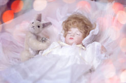 ベッドで眠っている幼い子どもの人形の画像